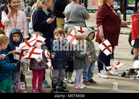 Chester, UK. 23rd April 2018. Children wave flags at the St George's Day parade through the city centre. The parade includes street performance, theatre and music with local school children performing many supporting roles. Credit: Andrew Paterson/Alamy Live News Stock Photo