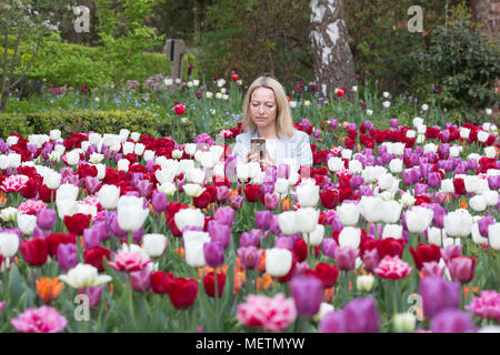 Eltham, United Kingdom. 23rd April, 2018. Elizabeth Cooper from London pictured enjoying the Tulip Festival at Eltham Palace. 40,000 tulips have been planted for the festival which lasts until mid May. Eltham Palace, managed by English Heritage, was a favourite palace of King Henry IV and it is where Henry VIII spent much of his childhood. Rob Powell/Alamy Live News Stock Photo