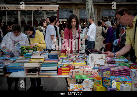 Barcelona, Catalonia, Spain. April 23, 2018 -  People  look at book's stall in the streets of Barcelona. Catalans celebrate the day of their patron saint, the  tradition of Sant Jordi's day (St George) commands men to give a rose to women and women give a book to men in a sign of love. Credit:  Jordi Boixareu/Alamy Live News Stock Photo