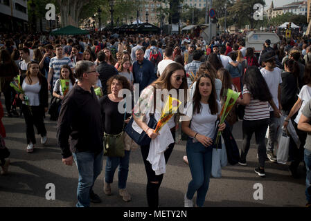Barcelona, Catalonia, Spain. 23rd Apr, 2018. People walk carrying roses in the streets of Barcelona. Catalans celebrate the day of their patron saint, the tradition of Sant Jordi's day (St George) commands men to give a rose to women and women give a book to men in a sign of love. Credit: Jordi Boixareu/ZUMA Wire/Alamy Live News Stock Photo