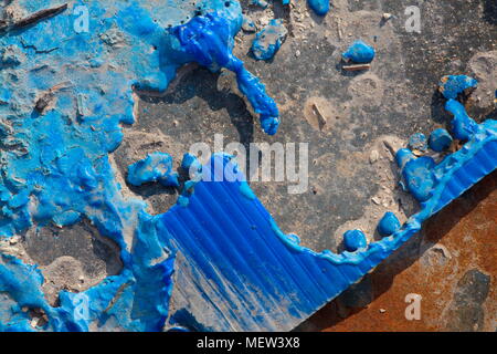 Blue melted plastic is covering a burned up garbage heap Stock Photo