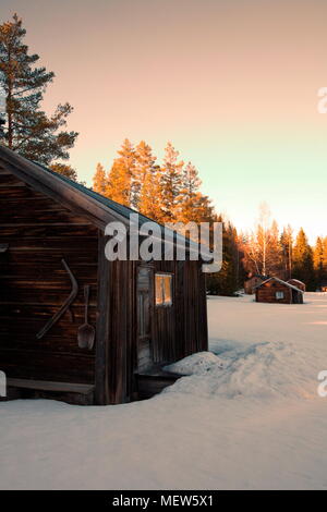Wooden log house in a snowy winter forest at sunset Stock Photo - Alamy