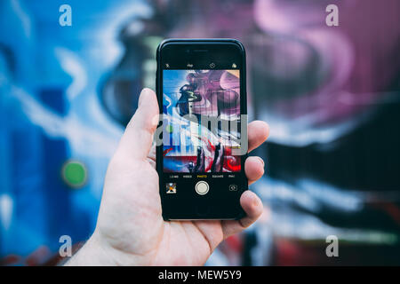 LONDON - APRIL 18, 2018: Man taking photo of street art in Shoreditch London Stock Photo