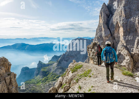 Pair of mountaineers walking a mountain path. Stock Photo
