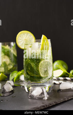 Mojito cocktail with garnishin glass on black table. Low key photo. Close up. Copy space. Stock Photo