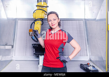 A young female technician while machine constructing in a manufacturing plant Stock Photo