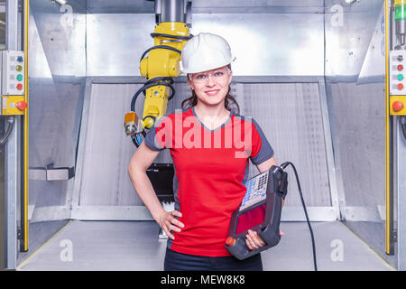 A young female technician while machine constructing in a manufacturing plant Stock Photo