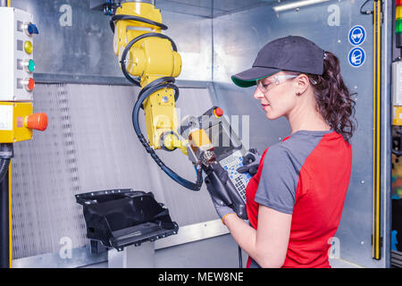 A young female technician while machine constructing in a manufacturing plant Stock Photo