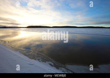 New ice is growing on a forest lake in late autumn. Stock Photo