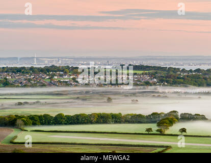 Misty dawn over the countryside, looking towards Portsmouth from the Isle of Wight. Stock Photo