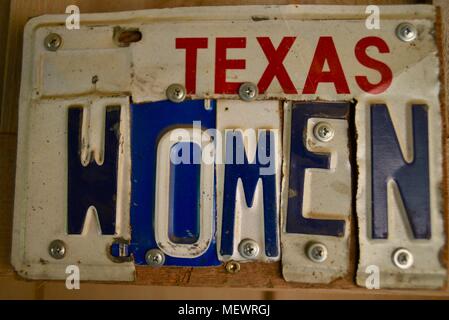 Metal 'Texas Women' bathroom sign with parts of vehicle license plates, at popular live country music venue and bar/saloon in Luckenbach, Texas, USA. Stock Photo