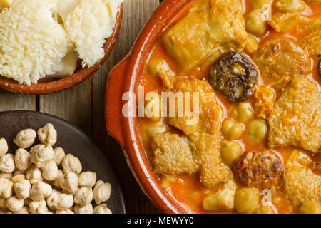 Close up of Spanish callos with chickpeas, with raw tripes and chickpeas on clay pots Stock Photo