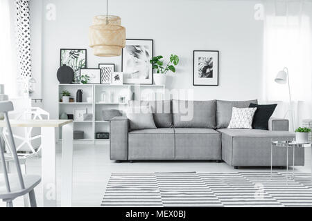 White studio interior in Scandinavian style with grey corner couch, modern art gallery and windows Stock Photo