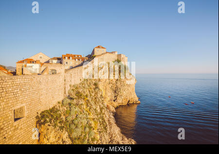 Panoramic view of the old town of Dubrovnik with calm sea in beautiful golden evening light at sunset with blue sky in summer, Dalmatia, Croatia Stock Photo