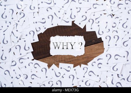 white paper note with question mark and word WHY in the center on wooden table. why concept background Stock Photo