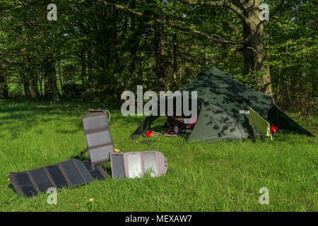 camping spot- big tent and three portable solar panels for recharging batteries Stock Photo
