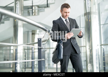 Modern businessman in office hall of large company Stock Photo