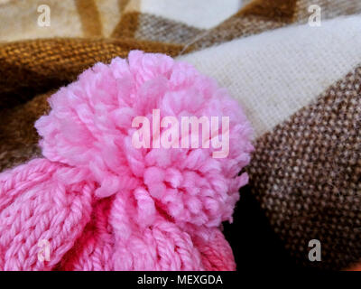 Handmade pink pompon on top of the winter hat close-up Stock Photo