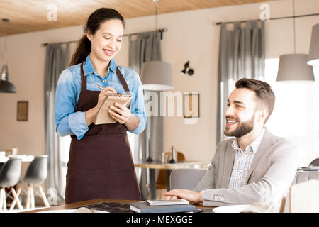 Friendly waitress taking order from customer Stock Photo