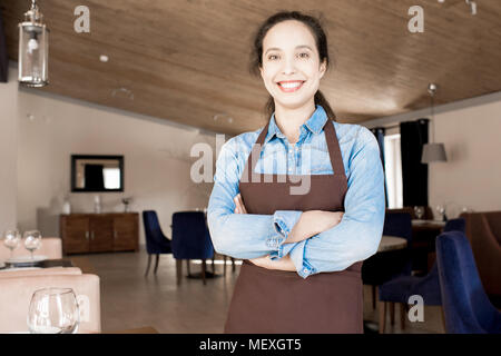 Cheerful beautiful waitress in cafe Stock Photo