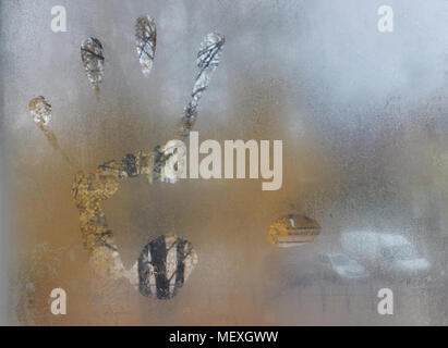 Close-up of the big male left hand print on the window, foggy autumn morning background Stock Photo