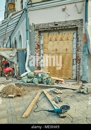 Two people in the red uniform working on the restoration of the old museum Stock Photo