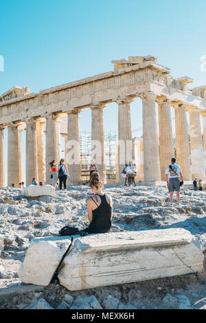 A girl sitting in front of the ancient temple of Parthenon, Acropolis, UNESCO World Heritage Site, Athens, Greece Stock Photo