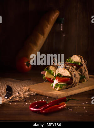 Still Life of Sandwich with ham, cheese, tomatoes, lettuce, and toasted bread Stock Photo