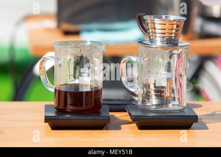 Making pour over coffee at the street market. Glass cups with dripper and filter Stock Photo