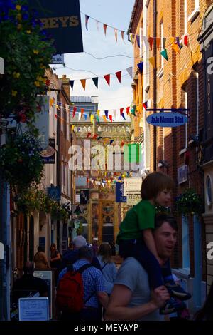 Gandy Street with Bunting in Exeter, Devon, UK. Narrow Cobbled Lane of Independent Shops. Supposedly the Inspiration for J.K. Rowling's  Diagon Alley. Stock Photo