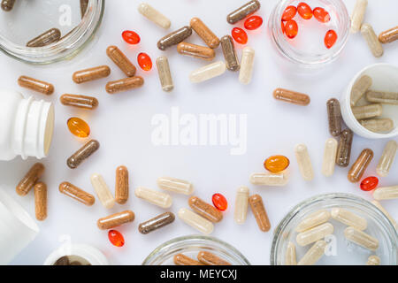 Different medicinal capsule, pills and jars on a light surface Stock Photo