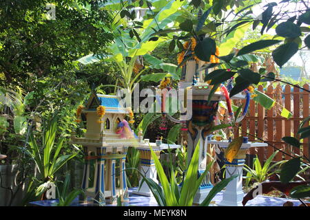 Thai shrine of household God, miniature spirit house in a garden. San Phra Phum, Thai house of the guardian spirit. Stock Photo