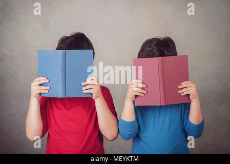 children reading a book on gray background Stock Photo