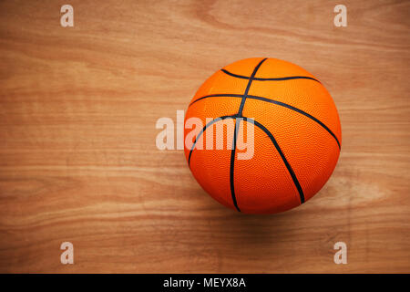 Basketball ball laying on hardwood court floor, top view Stock Photo