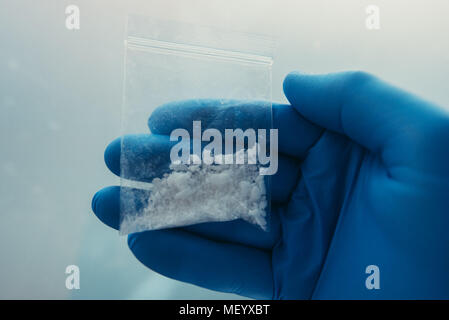 Criminology expert collecting drug evidence at crime scene, close up of hand Stock Photo