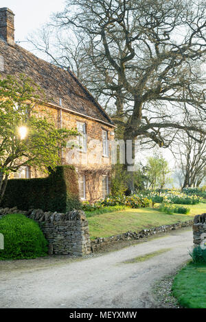 Morning spring sunlight on a cottage in the village of Little Tew, Oxfordshire, England
