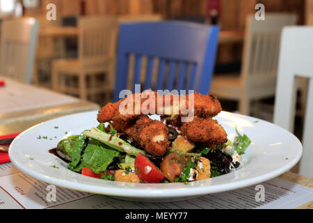 Breaded chicken salad, served in a restaurant setting Stock Photo