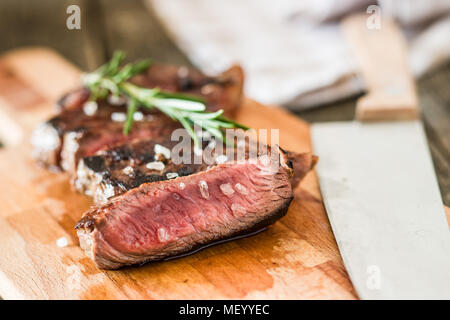 Sliced medium rare grilled steak on cutting board. Stock Photo