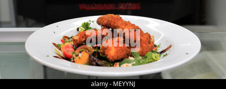 Breaded chicken salad, served in a restaurant setting Stock Photo