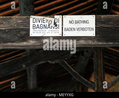 Signs in hot spring building. In the center of Bagno Vignoni dominates the old thermal pool. Today the pool is a protected monument and bathing is forbidden here. But the charm of the old bathing place is perfectly preserved. Several cafes and restaurants line the historic site, which has often been the backdrop for films. Stock Photo