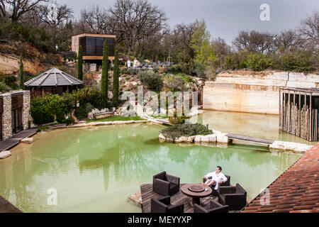 Hotel Adler Thermae, Bagno Vignoni, Tuscany with thermal pool, Tuscany, Val d'orcia Italy, UNESCO World Heritage. The hotel building in the style of a Tuscan villa is built in a former quarry. Thus, the hotel Adler Thermae blends into the UNESCO protected landscape Stock Photo