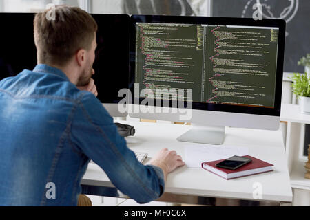 Introspective programmer examining code Stock Photo