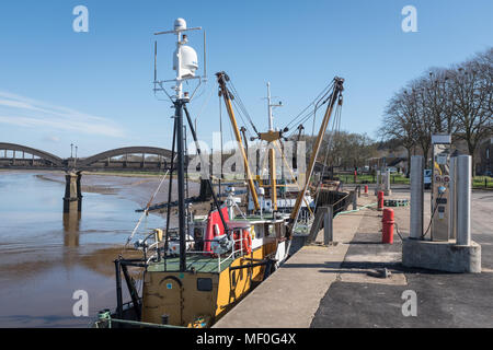 A view of Kirkcudbright harbour showing fishing boats moored at low tide on a sunny spring day. Stock Photo