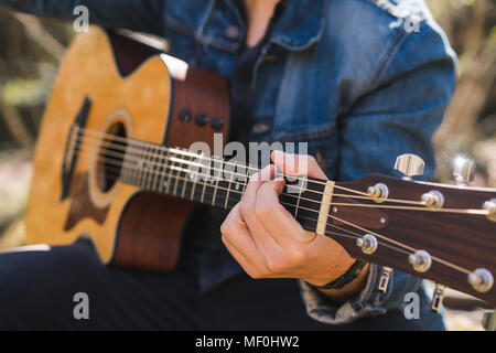 Close-up of man playing guitar outdoors Stock Photo