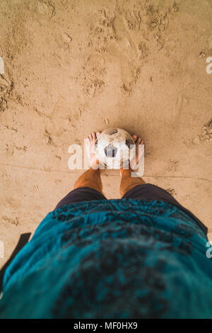 Low section of man with footall on the beach Stock Photo