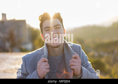 Portrait of smiling young man at twilight Stock Photo