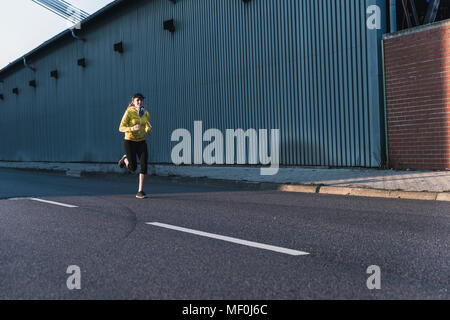 Young woman running on a street Stock Photo
