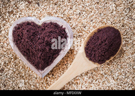 Acai powder in bowl on wooden background Stock Photo