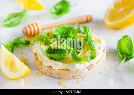 Healthy snack with crisp bread, lemon zest, honey and basil. Easy appetizer recipe. Stock Photo