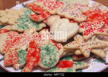 Plateful of Christmas cookies decorated with colorful sprinkles and glitter. Stock Photo